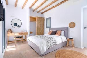 a bedroom with a bed and a desk and a television at IL Vento Premium in Mikonos