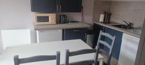 a small kitchen with a table and a microwave at La pavillonnaise in Les Pavillons-sous-Bois