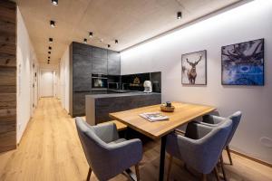 a kitchen and dining room with a wooden table and chairs at GRIMMINGlofts in Bad Mitterndorf