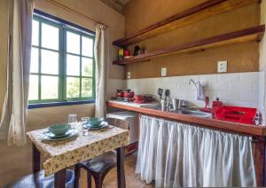 a kitchen with a sink and a counter with a table at Cafezal em Flor Turismo e Cafés Especiais in Monte Alegre do Sul
