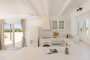 a white kitchen with a sink and a refrigerator at Villa Lotus - Ionian Villa Collection in Lixouri +32 photos
