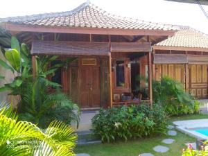 une maison avec une piscine en face de celle-ci dans l'établissement ASHVATTHA VILLA Canggu, à Canggu