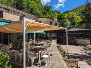 a restaurant with tables and chairs under an umbrella at Hotel il Rifugio del Lupo scanno in Scanno