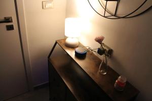una mesa con una lámpara y un jarrón de flores. en Casa Rodi, en Bari