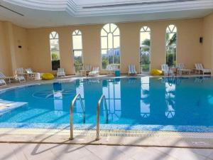 a large swimming pool in a hotel with tables and chairs at KhimA XL in Hammamet Sud