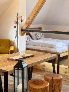 ハヴィジョフにあるApartmány Nad Pivovaremのベッドと木製テーブルが備わる客室です。