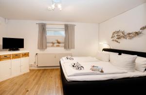 ein Schlafzimmer mit Bett und Flachbildfernseher in der Unterkunft Hüs Wüf im Haus Ornum in Westerland