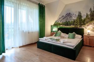 1 dormitorio con 1 cama grande y una pintura en la pared en Pokoje Gościnne MAGNAS, en Poronin