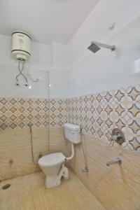 een badkamer met een toilet in een kamer met tegels bij Divine Glory Hotel in Lucknow +39 foto's