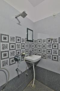 een badkamer met een wastafel en een spiegel aan de muur bij Divine Glory Hotel in Lucknow