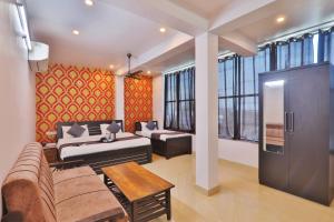 een woonkamer met een bank en een tafel bij Divine Glory Hotel in Lucknow