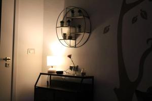 Habitación con mesa, lámpara y espejo. en Casa Rodi, en Bari