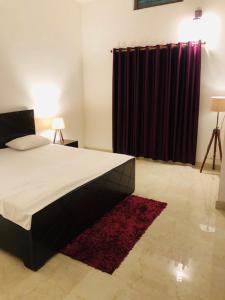 1 dormitorio con cama y cortina roja en Tattva Luxurious Apartment, en Varanasi