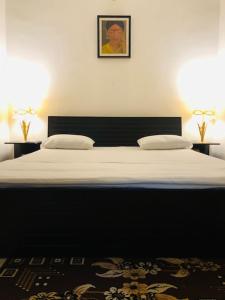1 dormitorio con 1 cama grande y 2 lámparas. en Tattva Luxurious Apartment, en Varanasi
