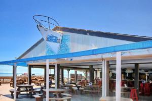 um restaurante com mesas e cadeiras de madeira num deque em Myrtle Beach Resort A316 em Myrtle Beach