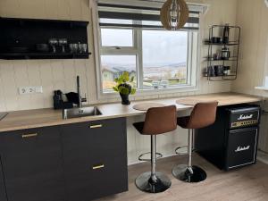 Una cocina con encimera y dos taburetes de bar. en Veigakot, en Akureyri 12 fotos más
