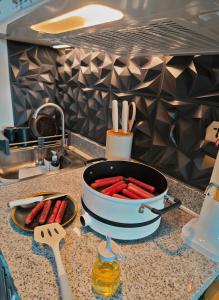 a pot of hot dogs on a kitchen counter at Elevate at 902 - Cityscape Tower Condominium - with Netflix, Near SM, Ayala, IT Park in Mandaue City