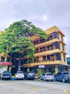 een groot gebouw met auto's geparkeerd voor het bij Arzo Hotel Grand Lodge in Manilla