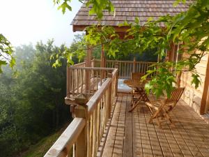 a wooden deck with two chairs and a table at Cabanes hobbit et Figuiers in Eyvignes-et-Eybènes