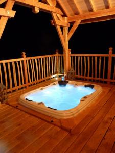 a hot tub in the middle of a wooden deck at Cabane-hobbit de Samsaget in Eyvignes-et-Eybènes