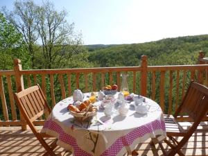 a table with a bowl of fruit on a porch at Cabanes hobbit et Figuiers in Eyvignes-et-Eybènes