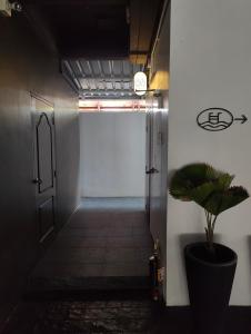 a hallway with a door and a potted plant at Room 36 Serviced Appartment - Skyline View in Bangkok