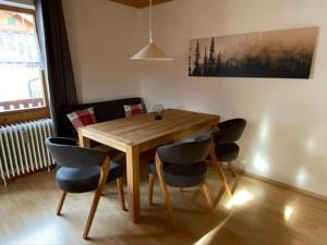 a wooden table and chairs in a living room at Ferienwohnungen Steigmühlenweg in Hinteregg