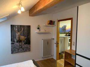 a bedroom with a picture of a deer on the wall at Ferienwohnungen Steigmühlenweg in Hinteregg