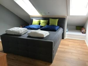 a bedroom with a black bed with yellow and blue pillows at Ferienwohnungen Steigmühlenweg in Hinteregg