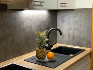 a pineapple and two oranges on a kitchen sink at Ferienwohnungen Steigmühlenweg in Hinteregg