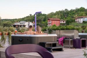 a man and a woman sitting in a bath tub at Hotel Le Palme in Dormelletto