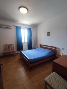 - une chambre avec un lit bleu et une fenêtre dans l'établissement Balestrate holiday home 70 Mq, à Balestrate