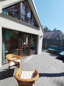 a patio with a couch and chairs on a deck at Stania Scandinavian CENTRUM in Boszkowo-Letnisko +1 photo