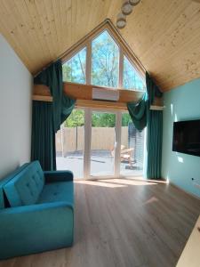 a living room with a blue couch and a large window at Stania Scandinavian CENTRUM in Boszkowo-Letnisko
