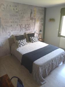 舊旺丹的住宿－Chambre d'hôtes "Sur la route des Terrils"，一间卧室配有一张床和涂鸦墙