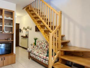 uma sala de estar com uma escada de madeira e um sofá em ISA HOUSE - Terrace with Valley view em Taceno