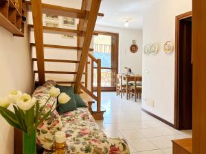 a living room with a couch and a staircase at ISA HOUSE - Terrace with Valley view in Taceno