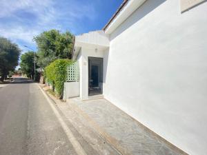 a white building with a door on the side of a street at San Teodoro - Civico 35 in San Teodoro