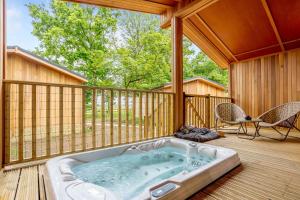 a jacuzzi tub on a deck on a house at Campden Lodge 1 in Kingham