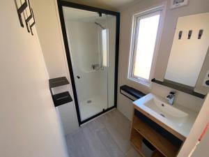 a bathroom with a sink and a shower at Camping Le Repos in Saint-Palais-sur-Mer
