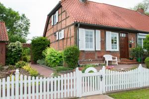 a white picket fence in front of a house at Elbwiesenhaus mit schönen Garten in Lenzerwische