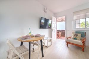 a dining room with a table and chairs and a television at Casa El Drago 1 in Breña Baja