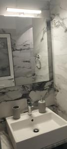 y baño con lavabo y espejo. en Sevilia Rooms, en Qeparo