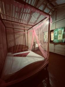 a small bed in a room with a mosquito net at Ocean View Cabana in Pottuvil
