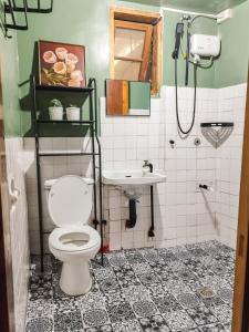 y baño con aseo y lavamanos. en Rm 204 Mhapiya-aw Pensione Inn, en Sagada