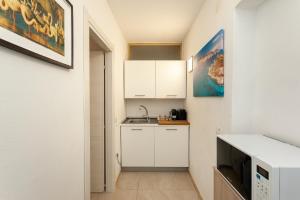 a small kitchen with white cabinets and a sink at San Teodoro - Civico 35 in San Teodoro
