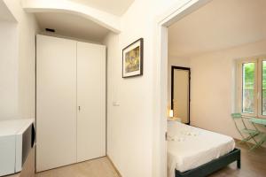 a white bedroom with a bed and a tv at San Teodoro - Civico 35 in San Teodoro +3 photos