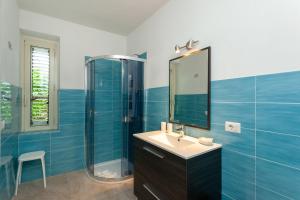 a blue bathroom with a sink and a mirror at San Teodoro - Civico 35 in San Teodoro
