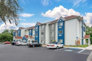 a large building with cars parked in a parking lot at Microtel Inn & Suites by Wyndham Brooksville in Ridge Manor