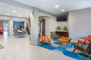 a lobby with a waiting area with chairs and tables at Microtel Inn & Suites by Wyndham Brooksville in Ridge Manor